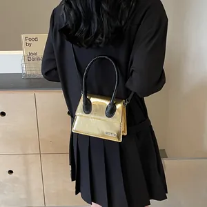 Bolso bandolera mini chic en oro metalizado con asa negra y correa para el hombro