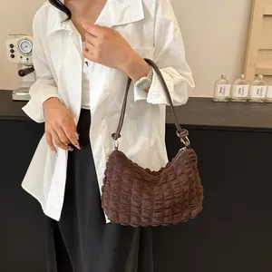 Gros plan du sac hobo marron foncé à texture plissée et bandoulière en cuir souple