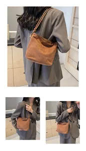 Close-up of caramel suede bucket bag featuring knotted straps and minimalist lettering