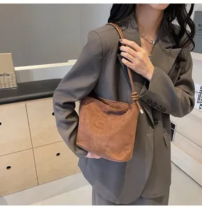 Brown suede tote bag detail showing knotted shoulder strap and elegant urban fashion style