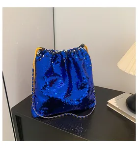 Detail of blue sequin bucket bag with golden chain strap and yellow drawstring closure