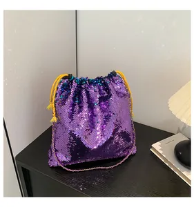 Detail of purple sequin drawstring bucket bag with yellow cord and metal chain strap