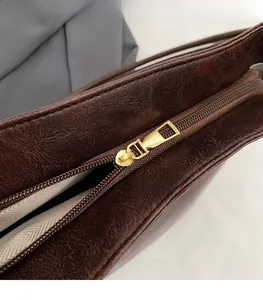 Close-up of premium brown suede bucket bag with smooth gold zipper and quality lining