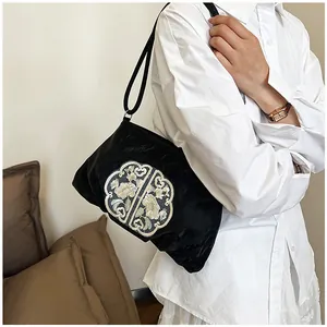 Dettaglio di borsa a spalla in velluto nero con ricamo floreale tradizionale cinese
