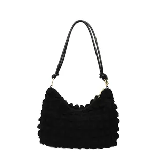 Sac à bandoulière noir à texture bulle avec fines lanières et détails de zip doré