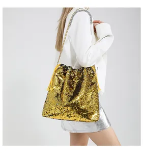 Detail of shimmering golden sequins and metallic chain strap on a designer bucket bag