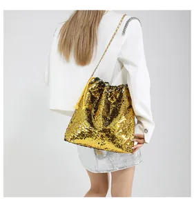 Detailed view of the sparkling gold sequin bucket bag with metal chain strap and drawstring