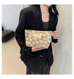 Detail der Canvas-Tasche mit Herzmuster, Perlengriff und FASHION BAG Webetikett