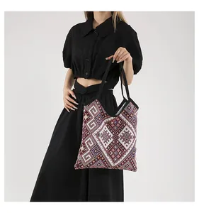Dettaglio borsa shopper in tessuto con motivi geometrici colorati e manici neri