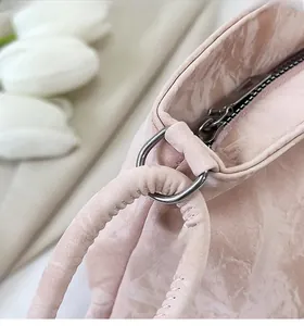 Dettaglio della borsa rosa strutturata con anello metallico argento e cuciture fini