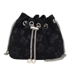 Black bucket bag with floral texture, silver chain strap and large pearl drawstrings