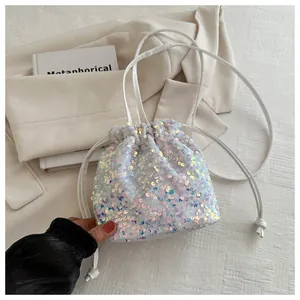 Detail of white sequin bucket bag showing iridescent glitter and drawstring strap