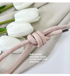 Dettaglio della tracolla regolabile in pelle rosa pallido con nodo e terminale in argento