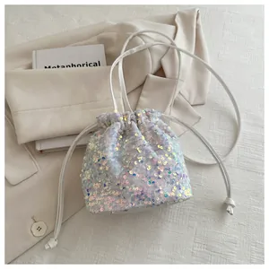 Detail view of iridescent sequins and drawstring closure on small bucket bag