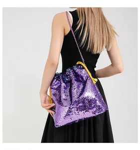 Detail of purple sequin bucket bag with yellow drawstring and metal chain strap