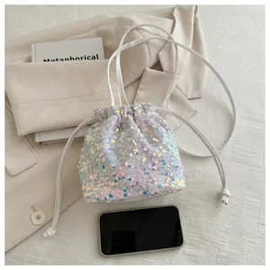 Detail of iridescent sequin bucket bag with drawstring closure and size reference
