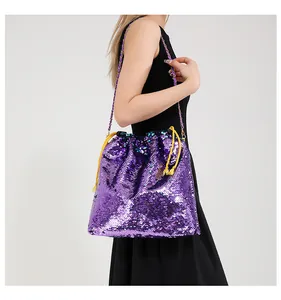 Detail of purple sequin bucket bag featuring yellow drawstrings and golden chain strap