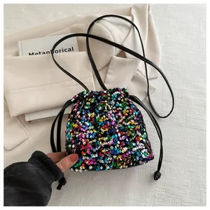 Close-up of colorful sequin bucket bag with drawstring closure and slim leather strap