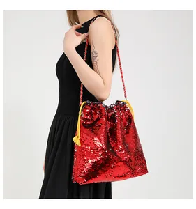 Close-up of red sequin drawstring bucket bag with yellow tassels and metal chain strap