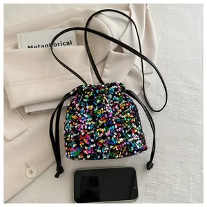 Macro shot of colorful sequin bucket bag with black drawstring and shoulder strap details