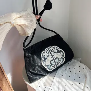 Elegante borsa a tracolla nera a pieghe con ricami cinesi e tracolla con nodi