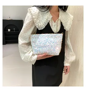Close-up of sparkling sequin handbag with gold zipper and iridescent shimmering texture