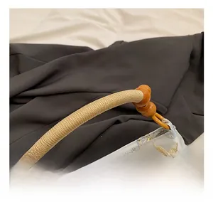 Detail von Bambusgriff und Schmetterlingsstickerei auf hellblauer Satin-Tasche