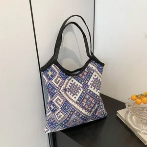 Borsa tote in maglia con strisce etniche colorate su tavolo in legno scuro