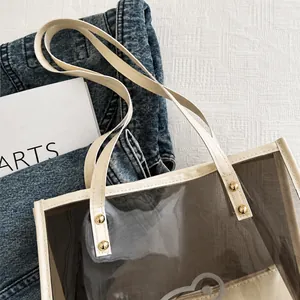 Detailansicht der braunen PVC-Tasche mit cremefarbenen Ledergriffen und Goldnieten