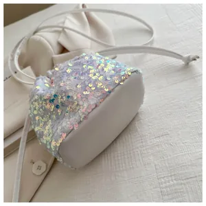 Detailed view of iridescent sequin bucket bag with white drawstring and leather base