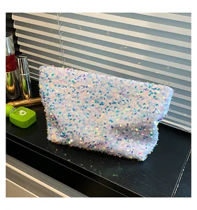 Detail showing white iridescent sequins and silver zipper on the trapezoid makeup bag
