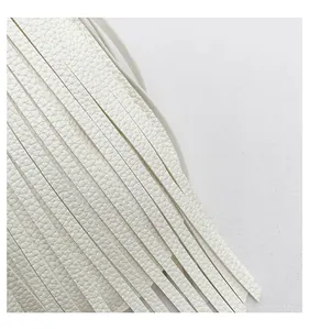 Detailed view of white litchi textured leather tassels and premium material finish