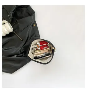 Innenansicht der schwarzen Canvas-Kosmetiktasche mit Lippenstiften und Make-up