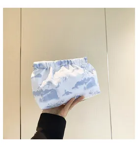 Detail of a portable fabric pouch with blue landscape print and drawstring closure