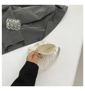 Detailed view of white fringed crossbody bag with magnetic closure and clean inner lining