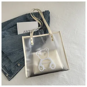 Close-up of PVC clear jelly tote bag featuring a cute cartoon bear print and leather handles