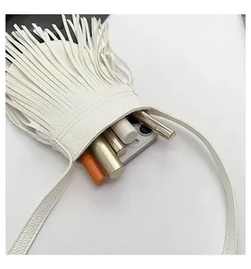Close-up of white fringe crossbody bag interior showing storage capacity for phone and lipstick