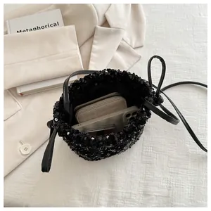 Detail shot of black sequin bucket bag showing large interior space for wallet and phone