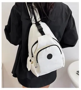 Detail of white nylon chest bag with sport logo patch and adjustable black strap