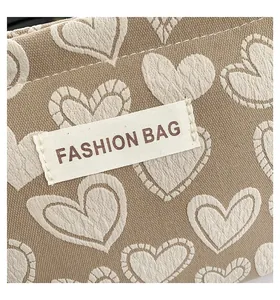 Nahaufnahme der khakifarbene Segeltuchtasche mit Herzmuster und aufgenähtem Fashion-Bag-Etikett