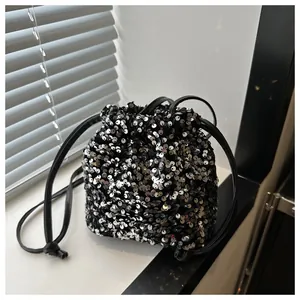Detailed close-up of shiny silver sequins and drawstring closure on a mini bucket bag
