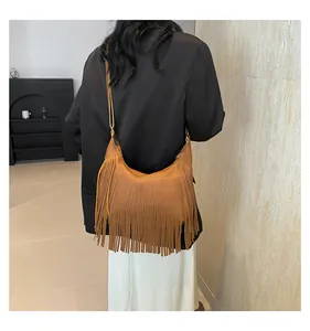 Dettaglio di borsa hobo marrone in finta pelle scamosciata con frange boho e tracolla