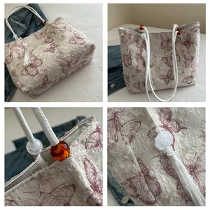Detail of jacquard tote bag with butterfly patterns, fringe edges and beaded handle