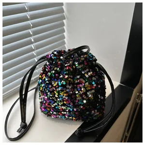 Close-up of a colorful sequin bucket bag with drawstring closure on a white surface