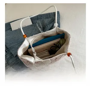 Top view of white tote bag interior showing capacity for tablets and books