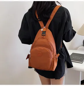 Rear view of a casual orange chest bag with front zipper pocket and adjustable straps