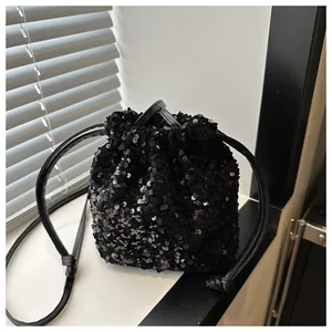 Macro shot of shimmering black sequins and drawstring closure on a bucket bag
