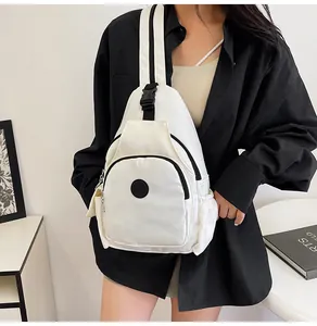 Minimalist white nylon chest bag with black adjustable straps and multiple zip compartments