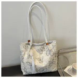 Detail of off-white butterfly tote bag with plush texture and woven rope handles