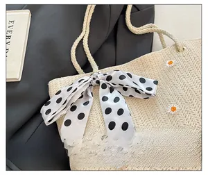 Détail du sac en paille avec broderie marguerite et foulard à pois noirs et blancs